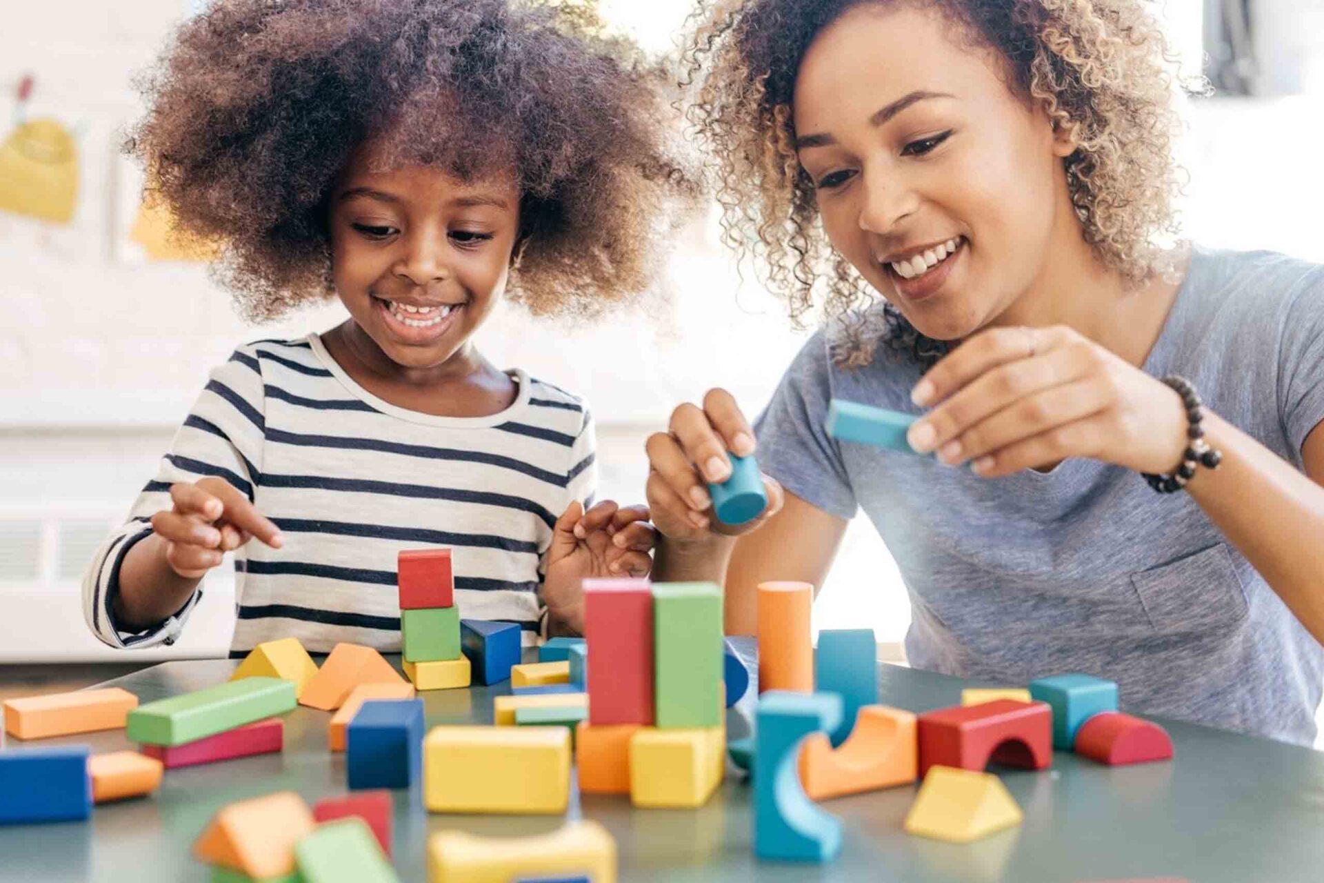 A Teacher and a child playing with the blocks